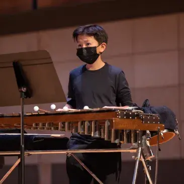 a pre-college percussionist watches the conductor