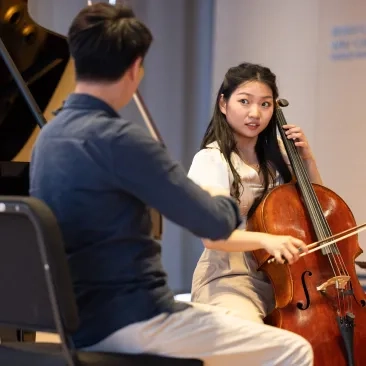 Yip-Wai Chow (left) and Alexandra Kim perform for Michael Tilson Thomas.