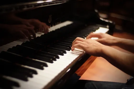 Hands playing on piano. 