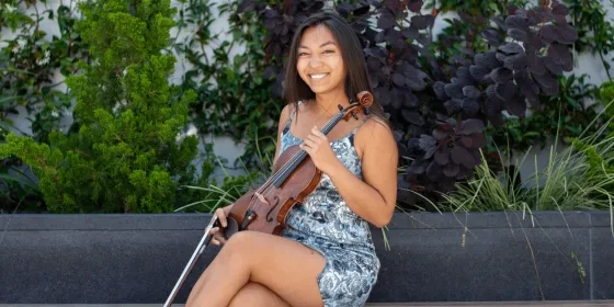 Rose Crelli holds a violin at The Bowes Center