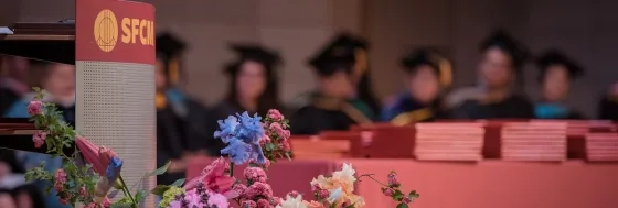 Empty stage with flowers and commencement banner